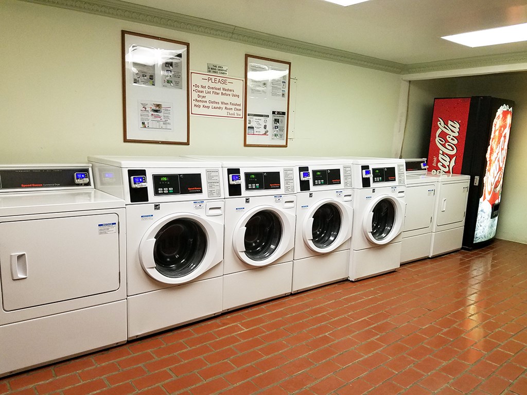 a row of washers and dryers in a laundry room
